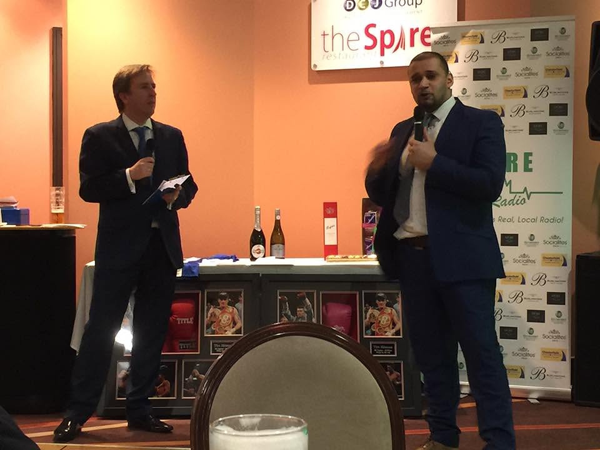 Nick Johnson interviewing a sporting guest on stage at a charity dinner