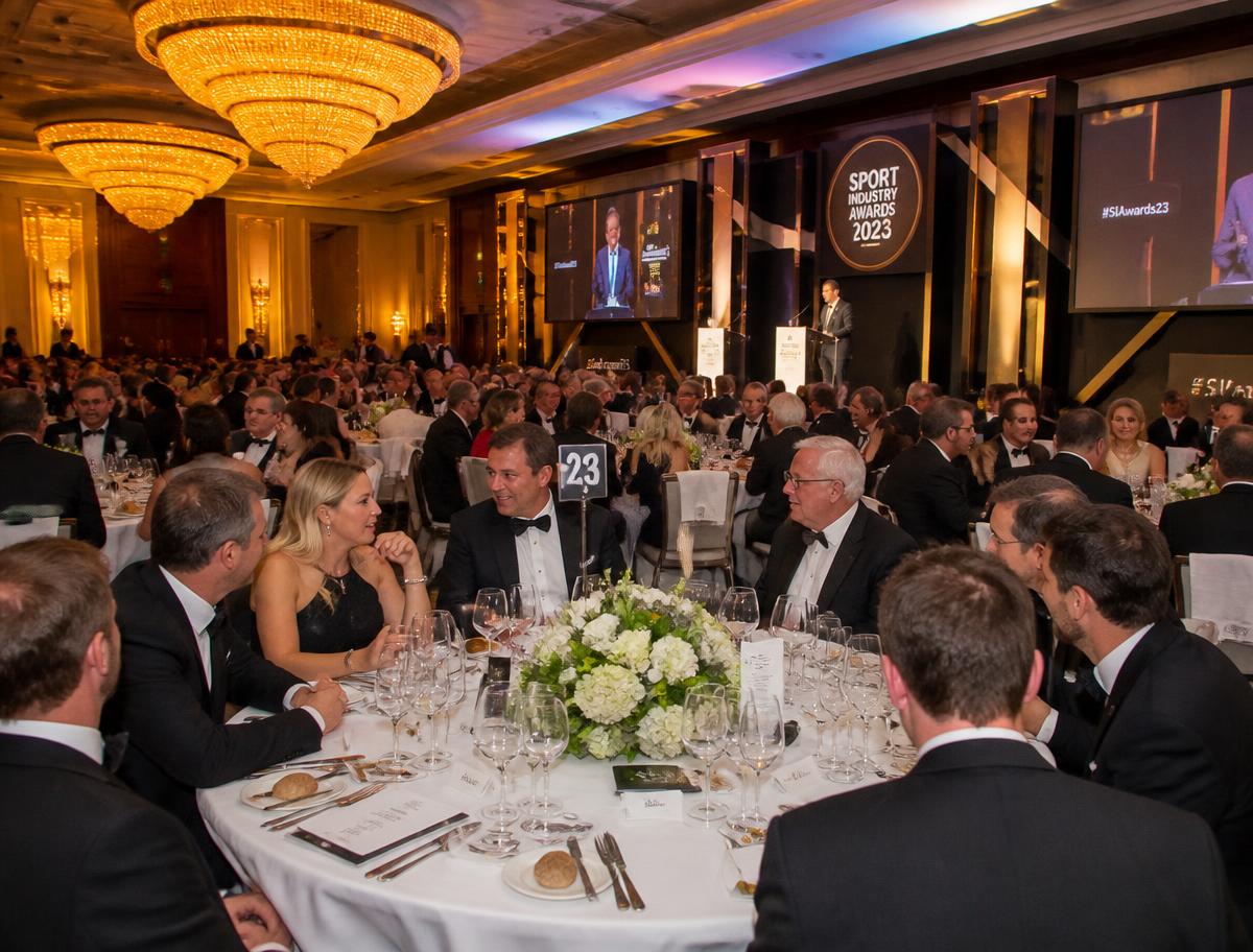 Sporting dinner in a ballroom lit by chandeliers